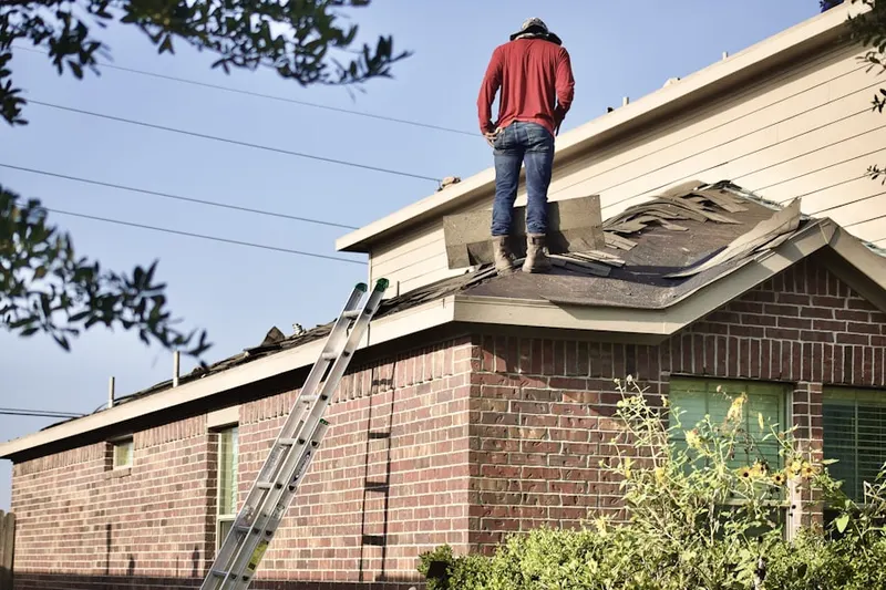 Professional roofer working on a residential roof in Orchard Glen